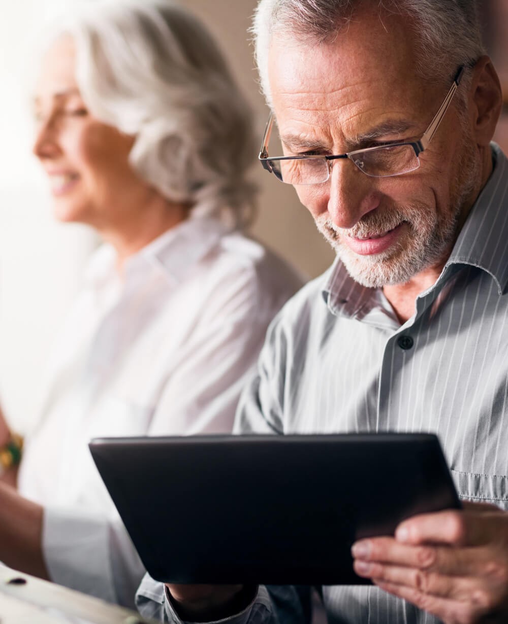 An older couple looks at a tablet computer. An older couple looks at a tablet computer.