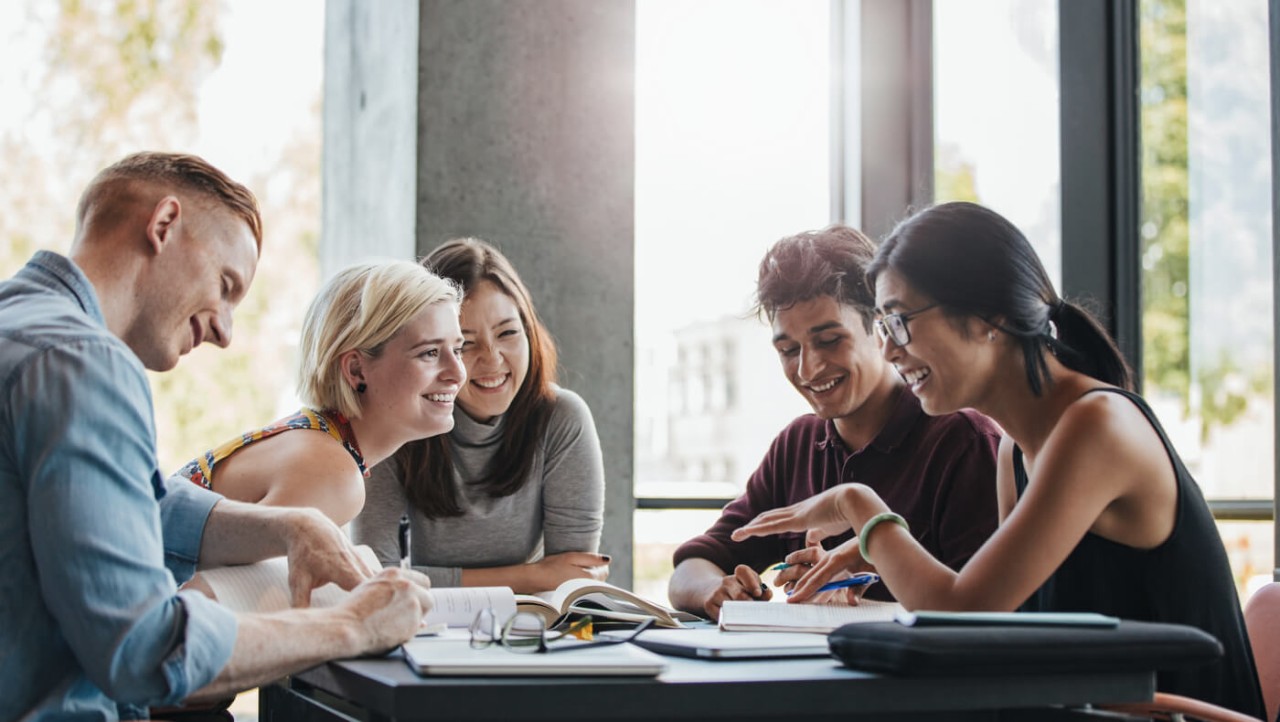 Cinq jeunes adultes parlent autour d'une table Cinq jeunes adultes parlent autour d'une table